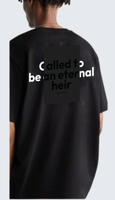 Black t-shirt with text on the back worn by a person, on a light gray background